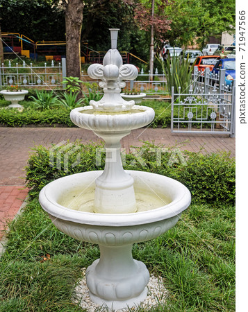 Decorative white the fountain on green grass Decorative white the fountain on green grass 71947566