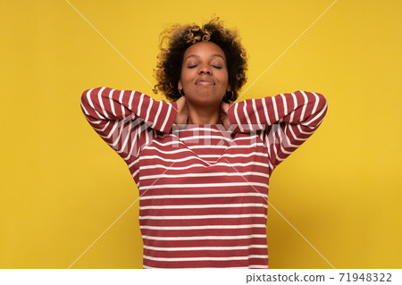 African young woman has a sore neck, isolated on a yellow background African young woman has a sore neck, isolated on a yellow background 71948322