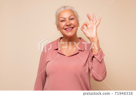 Senior woman doing ok gesture with hand smiling approving your choice. Senior woman doing ok gesture with hand smiling approving your choice. 71948338