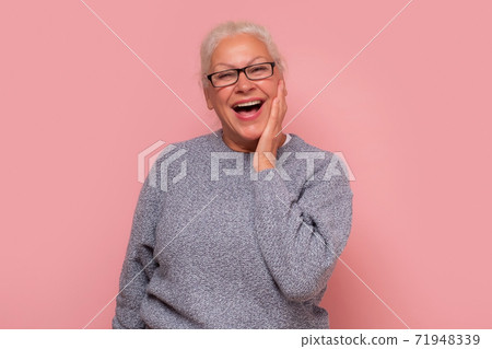 Surprised elderly lady with hands on face see the unbelievable. Surprised elderly lady with hands on face see the unbelievable. 71948339