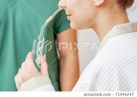 Woman receives nasal inhalation. Woman receives nasal inhalation. 71949247