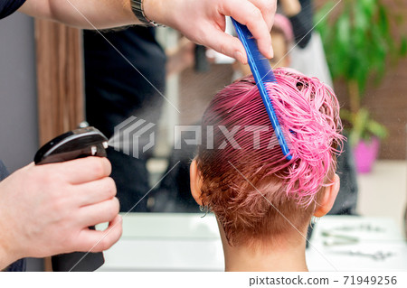 Hairdresser sprinkles water on hair. Hairdresser sprinkles water on hair. 71949256