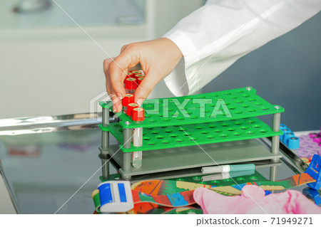 Technician puts test tube to rack Technician puts test tube to rack 71949271