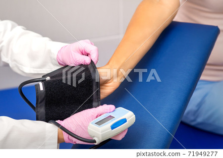 Doctor puts on tonometer on arm Doctor puts on tonometer on arm 71949277