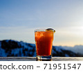 Orange drink against mountain at sunset. 71951547