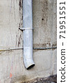 Vertical drain pipe on dirty concrete wall. 71951551