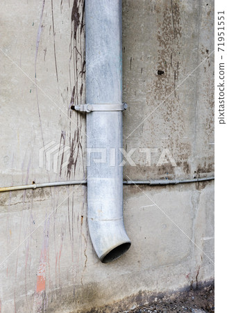 Vertical drain pipe on dirty concrete wall. 71951551