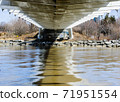 Under metal bridge crossing muddy river. 71951554
