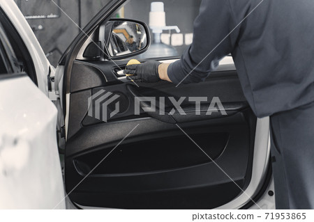 Man polish salon of car in a garage 71953865