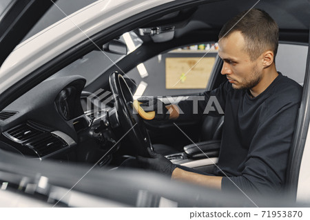 Man polish salon of car in a garage 71953870