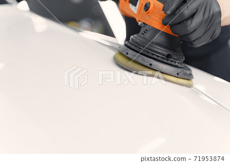 Man polish a car in a garage Man polish a car in a garage 71953874