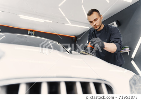Man polish a car in a garage Man polish a car in a garage 71953875