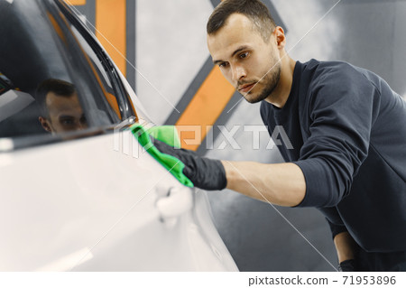 Man polish a car in a garage 71953896