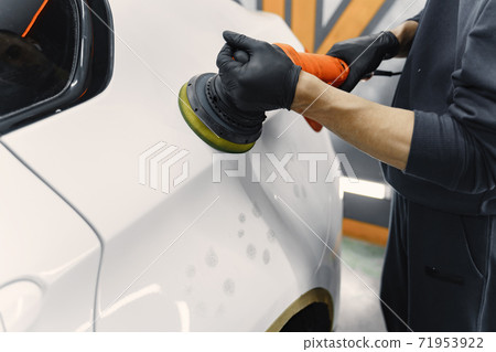 Man polish a car in a garage 71953922