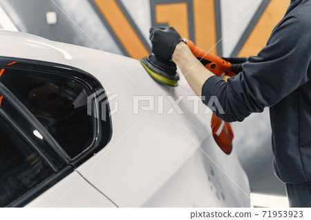 Man polish a car in a garage 71953923