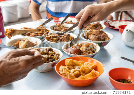People eating variety of authentic bak kut teh, popular Chinese food in Klang, Malaysia People eating variety of authentic bak kut teh, popular Chinese food in Klang, Malaysia 71954371