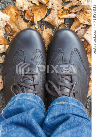 Comfortable brown leather shoes for men on asphalt road or footpath with autumnal leaves Comfortable brown leather shoes for men on asphalt road or footpath with autumnal leaves 71959832