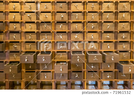 Traditional chinese pharmacy shop. Ancient herbs pharmacy cabinet wooden drawers in background 71961532