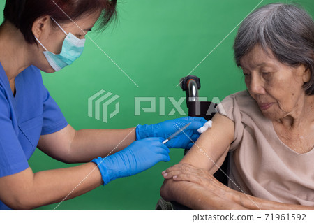Chroma key, nurse doing vaccine injection to senior woman. Chroma key, nurse doing vaccine injection to senior woman. 71961592