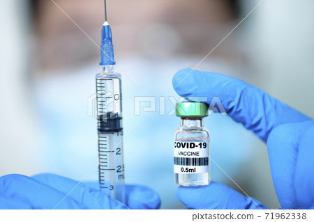 Doctor showing COVID-19 Vaccine and syringe injection. 71962338