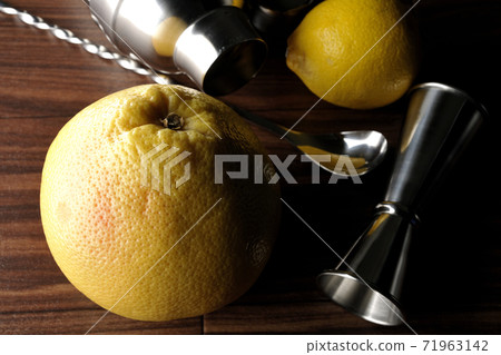 Make a cocktail with a shaker using grapefruit and lemon Make a cocktail with a shaker using grapefruit and lemon 71963142