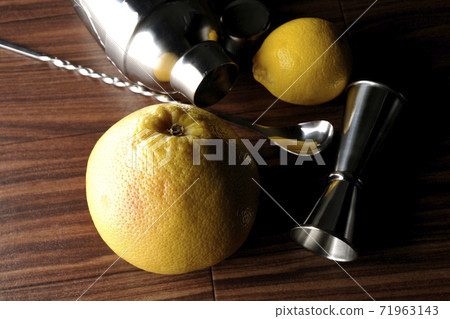 Make a cocktail with a shaker using grapefruit and lemon Make a cocktail with a shaker using grapefruit and lemon 71963143