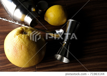 Make a cocktail with a shaker using grapefruit and lemon Make a cocktail with a shaker using grapefruit and lemon 71963144