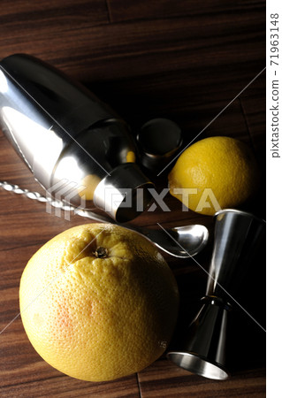 Make a cocktail with a shaker using grapefruit and lemon Make a cocktail with a shaker using grapefruit and lemon 71963148