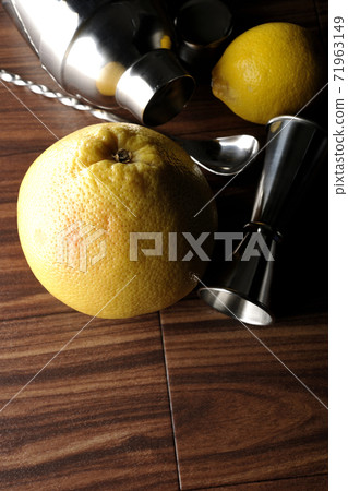 Make a cocktail with a shaker using grapefruit and lemon Make a cocktail with a shaker using grapefruit and lemon 71963149