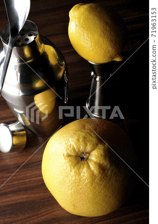 Make a cocktail with a shaker using grapefruit and lemon 71963153