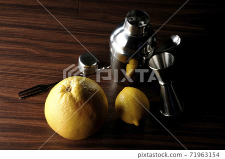 Make a cocktail with a shaker using grapefruit and lemon 71963154