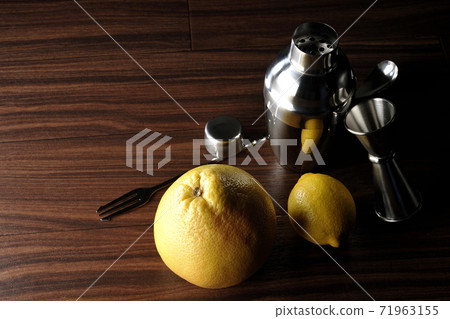 Make a cocktail with a shaker using grapefruit and lemon 71963155