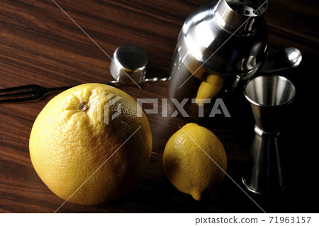 Make a cocktail with a shaker using grapefruit and lemon Make a cocktail with a shaker using grapefruit and lemon 71963157