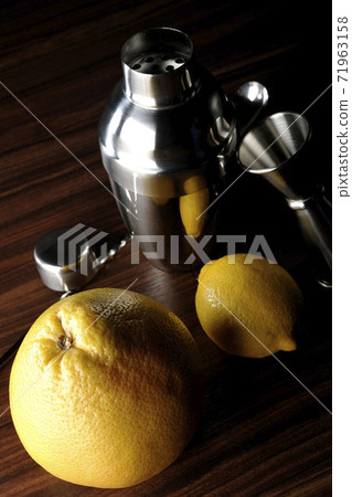 Make a cocktail with a shaker using grapefruit and lemon Make a cocktail with a shaker using grapefruit and lemon 71963158