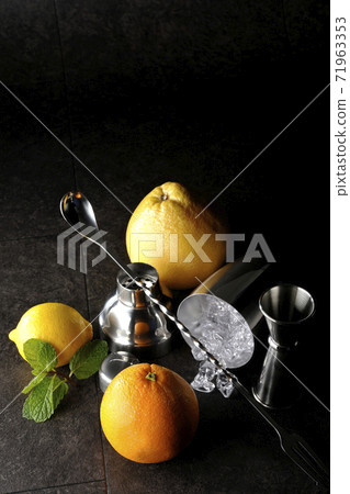 Make a cocktail with a shaker using grapefruit, orange, lemon and mint 71963353