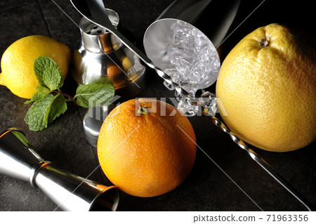 Make a cocktail with a shaker using grapefruit, orange, lemon and mint Make a cocktail with a shaker using grapefruit, orange, lemon and mint 71963356