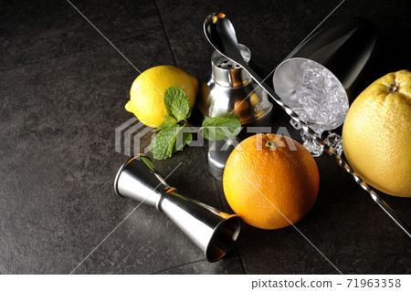 Make a cocktail with a shaker using grapefruit, orange, lemon and mint Make a cocktail with a shaker using grapefruit, orange, lemon and mint 71963358