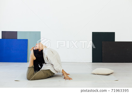 Brunette woman engaged in yoga asana gymnastics fitness flexibility body sport Brunette woman engaged in yoga asana gymnastics fitness flexibility body sport 71963395