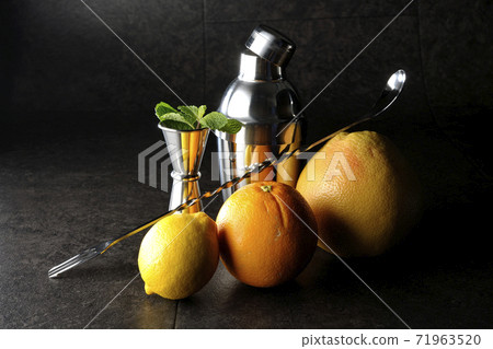 Make a cocktail with a shaker using grapefruit, orange, lemon and mint 71963520