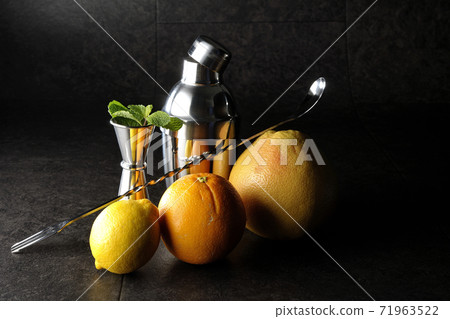Make a cocktail with a shaker using grapefruit, orange, lemon and mint Make a cocktail with a shaker using grapefruit, orange, lemon and mint 71963522