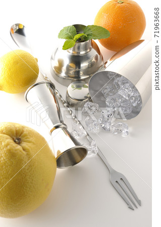 Make a cocktail with a shaker using grapefruit, orange, lemon and mint (white background) Make a cocktail with a shaker using grapefruit, orange, lemon and mint (white background) 71963668