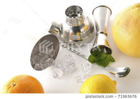 Make a cocktail with a shaker using grapefruit, orange, lemon and mint (white background) Make a cocktail with a shaker using grapefruit, orange, lemon and mint (white background) 71963676