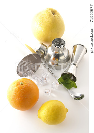 Make a cocktail with a shaker using grapefruit, orange, lemon and mint (white background) Make a cocktail with a shaker using grapefruit, orange, lemon and mint (white background) 71963677