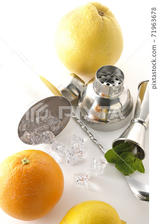 Make a cocktail with a shaker using grapefruit, orange, lemon and mint (white background) Make a cocktail with a shaker using grapefruit, orange, lemon and mint (white background) 71963678