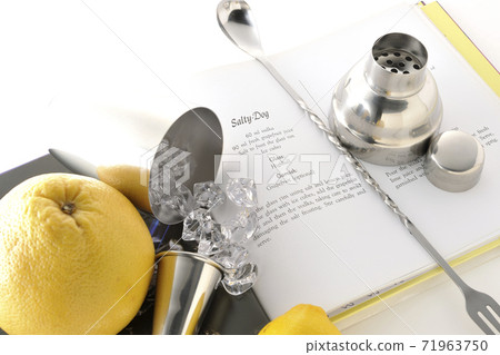 Make a cocktail with a shaker while looking at a cocktail book using grapefruit and lemon (white background) Make a cocktail with a shaker while looking at a cocktail book using grapefruit and lemon (white background) 71963750