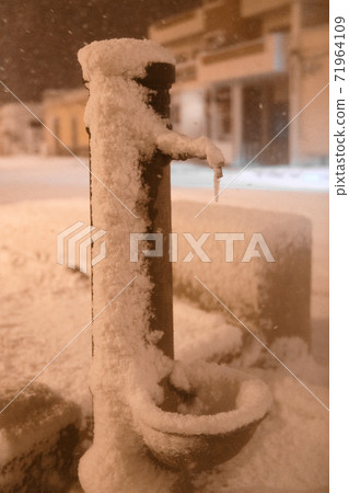 Typical drinking fountain in the south of Italy, under the snow after an unusual snowfall in Puglia 71964109