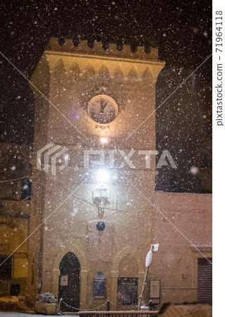 Clock tower in tiny Italian paese Avetrana under the snow after an unusual snowfall in Puglia 71964118