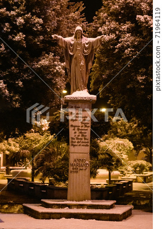 The statue of Christ in the snow in Piazza Giovanni XXIII. The street of Avetrana town under the snow after an unusual snowfall in Puglia 71964119