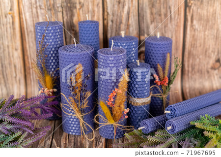 Lilac honey candles handmade from natural wax on a background of wooden boards. Elements from natural materials. Christmas or New Year's composition. Photo for postcards. Lilac honey candles handmade from natural wax on a background of wooden boards. Elements from natural materials. Christmas or New Year's composition. Photo for postcards. 71967695