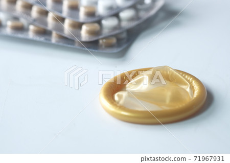 close up of condom and birth control pill on white  71967931